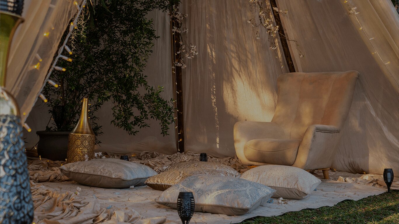 Cozy retreat tent with armchair, cushions and warm lantern light